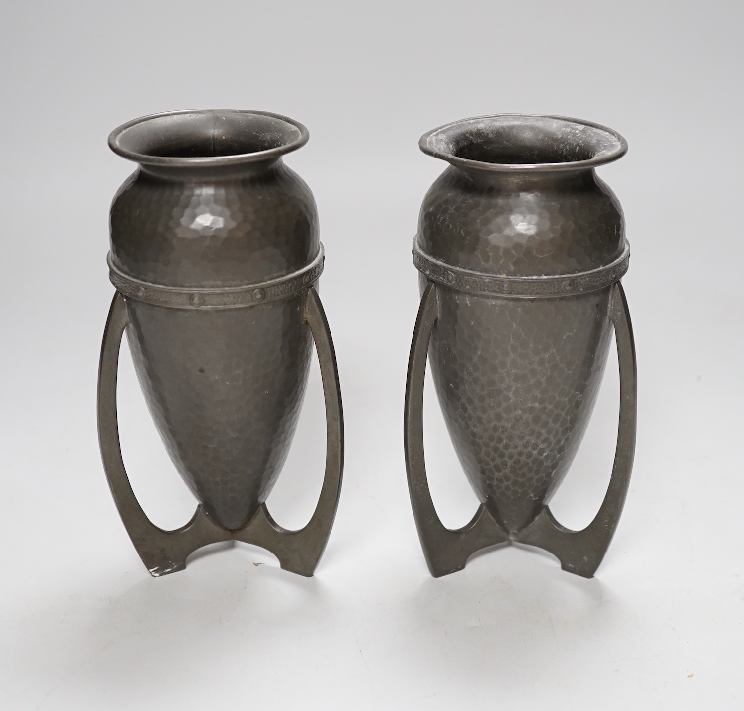 After Archibald Knox, pair of Art Nouveau style hammered pewter vases, 17cm high